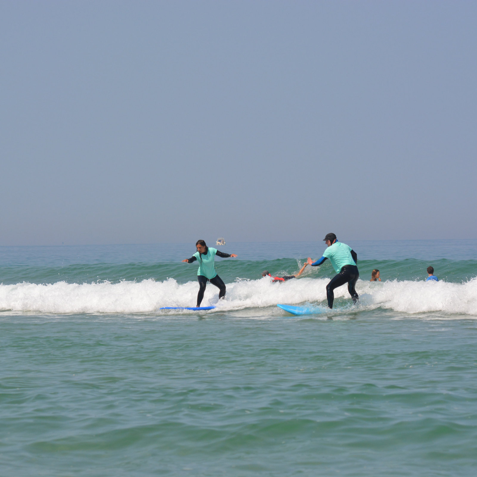 Alumnos aprendiendo a surfear en la espuma